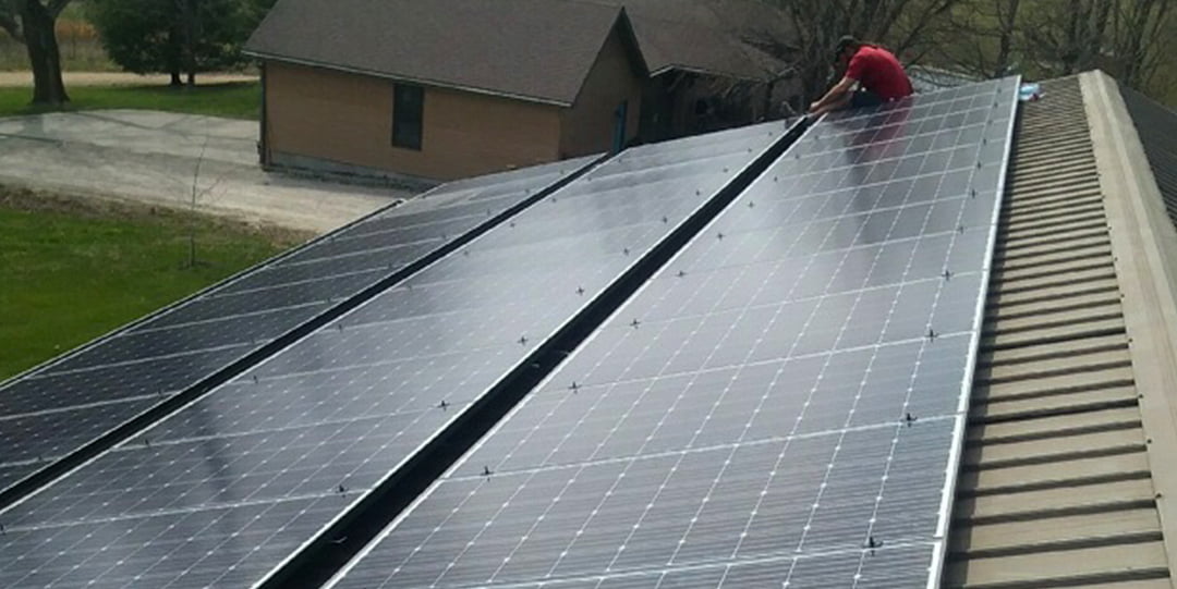 A long shot of solar panels that sit atop the roof of a metal building. These solar panels were installed by On Grid Off Grid Solar of Joplin, MO.